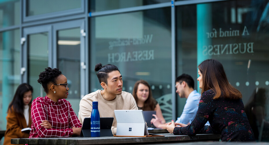 Business School students studying together outside the Business School