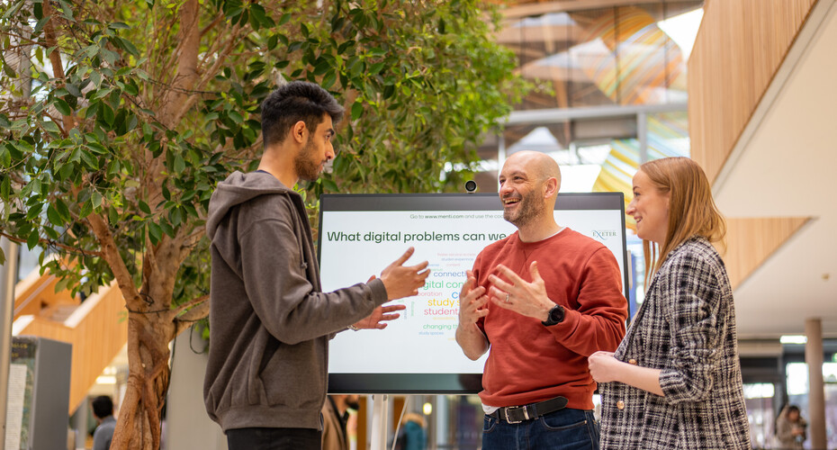 Students talking with digital problems marketing sign behind them