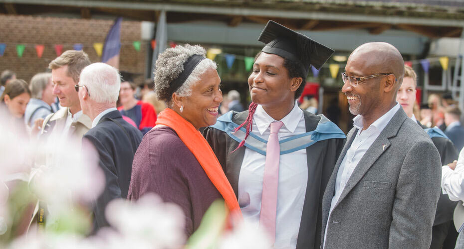 A student with their parents at graduation