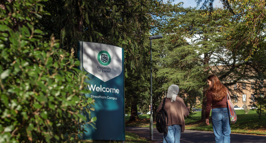 Students walking past campus sign