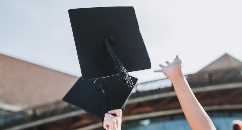Close up of motarboard hat being thrown into the sky