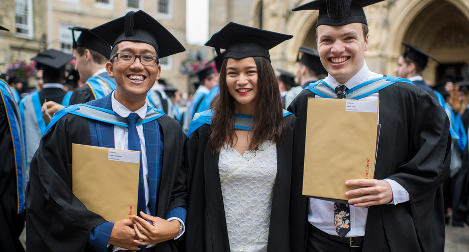 Three graduates outside truro Cathedral at summer graduation 2019.