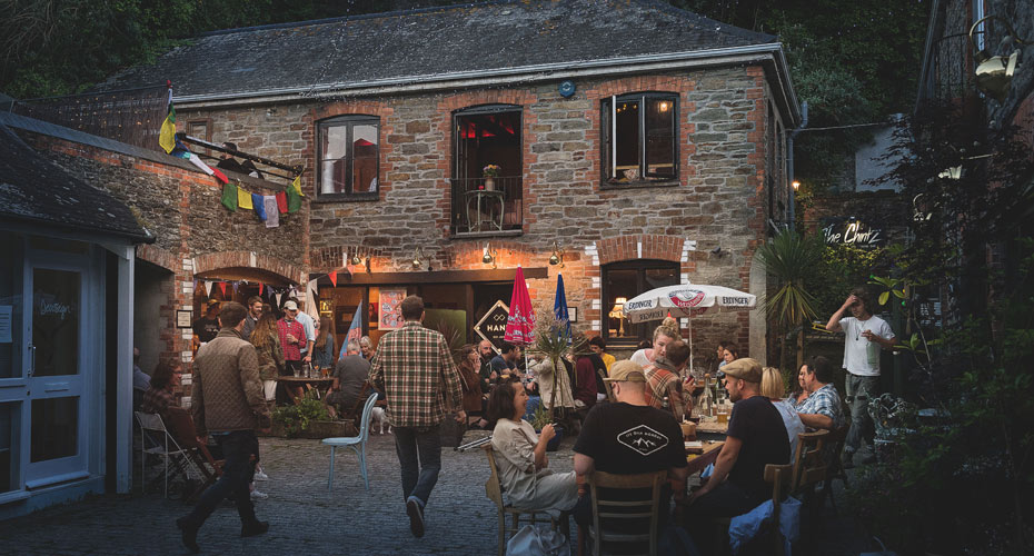 People socialising at tables outside a Cornwall pub in the evening