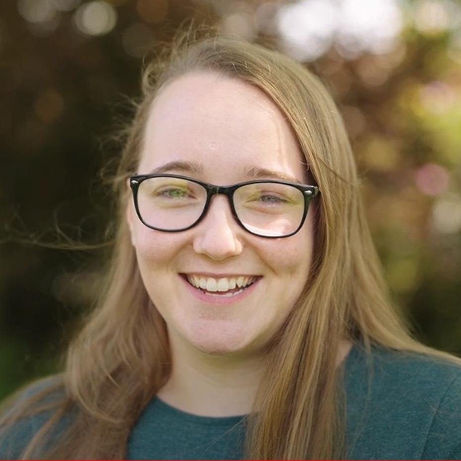 Headshot of lady with long hair and glasses smiling