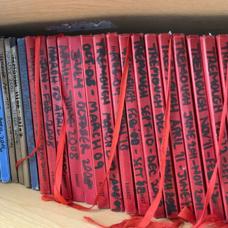 Red notebooks in a row on bookshelf