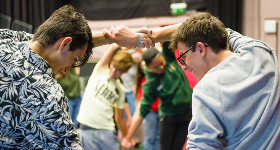 Students holding hands dancing