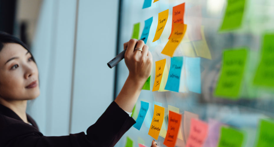 A woman writing on coloured post it notes