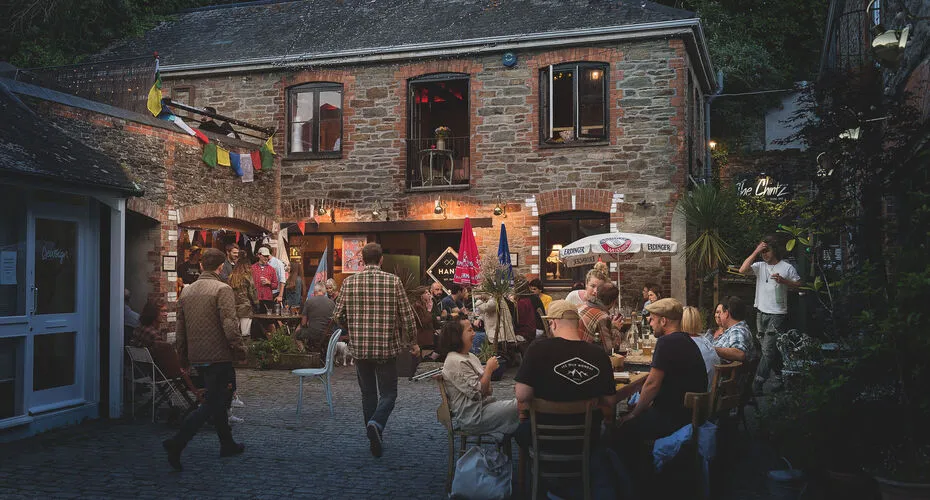 People drinking outside an old stone pub in Falmouth
