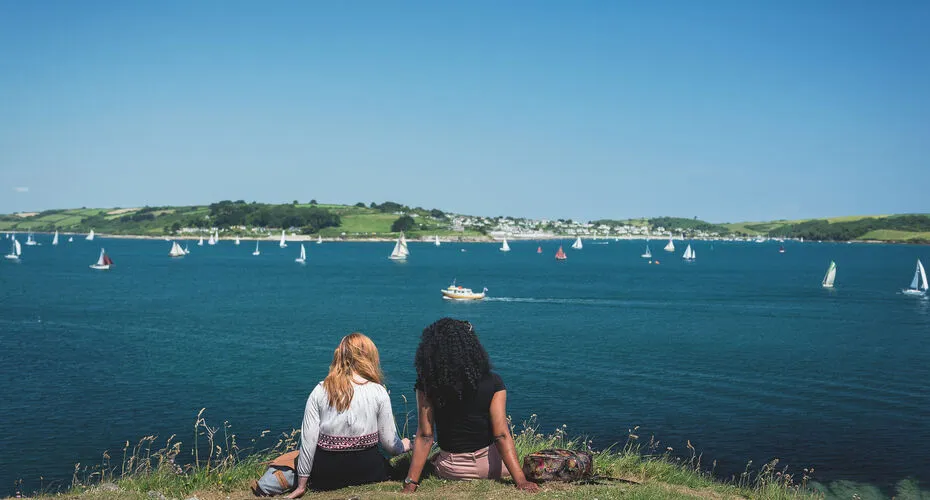 Students sat looking at sailing boats in Falmouth harbour