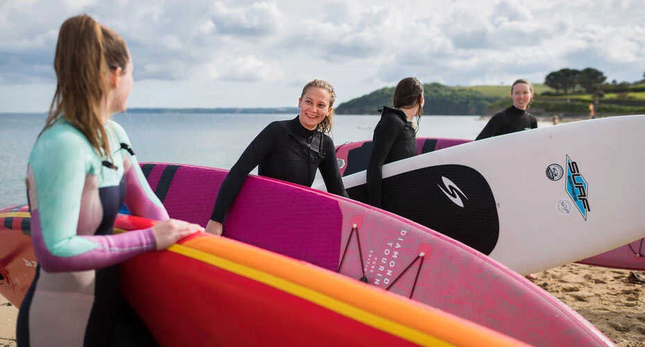 Paddleboarders emerge from the sea in Falmouth