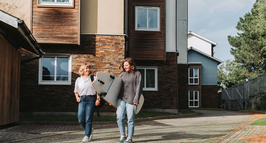 A pair of students outside of University accommodation on Penryn Campus in Cornwall.