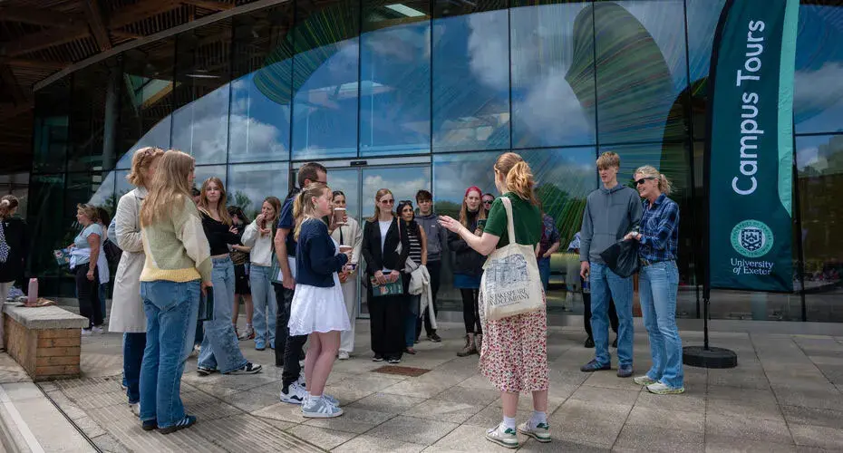 A student leading a campus tour with a group of prospective students and parents