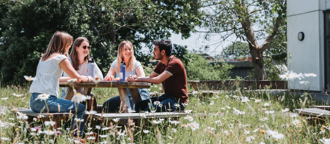 A group of students socialising outdoors on our beautiful Penryn Campus.
