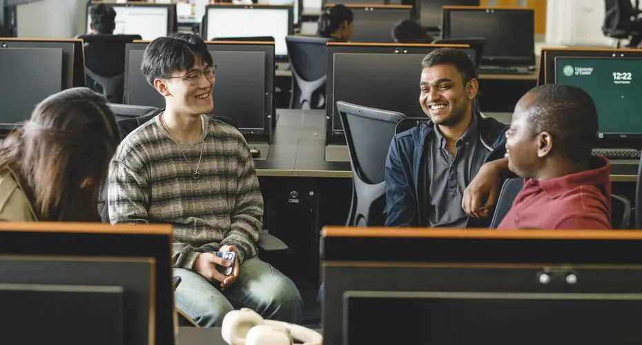 Students laughing together in a computer lab