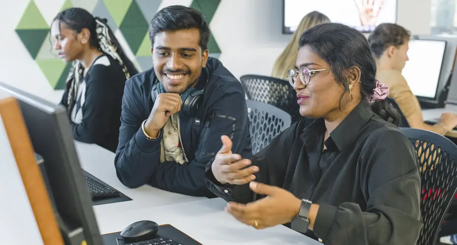 Students chatting and smiling in a computer lab