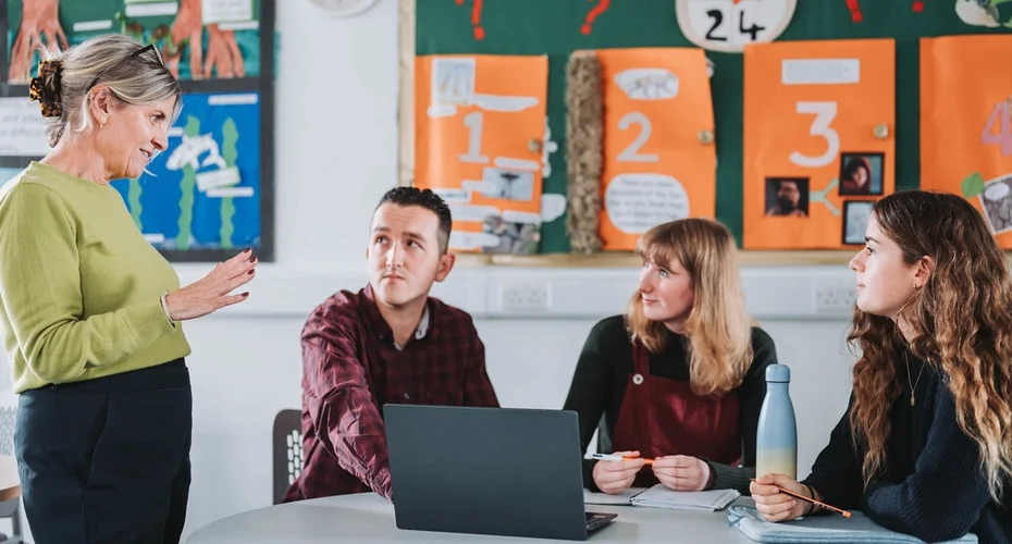 Students and staff talking in the communal study area in Baring Court on St Luke's Campus.