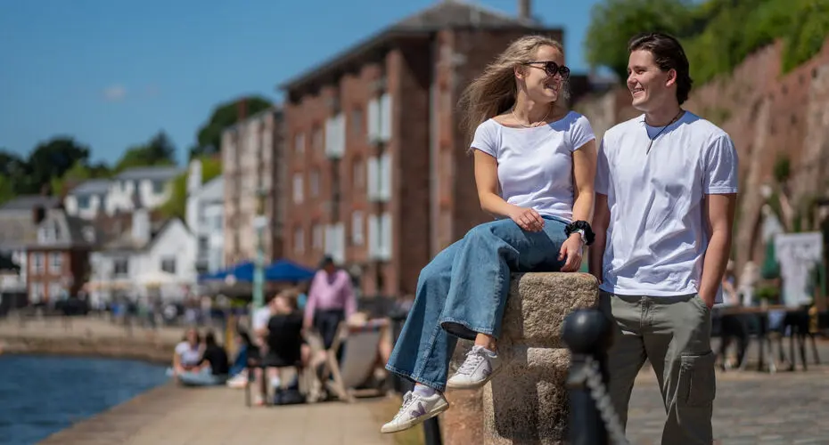 Students sitting by the river in Exeter
