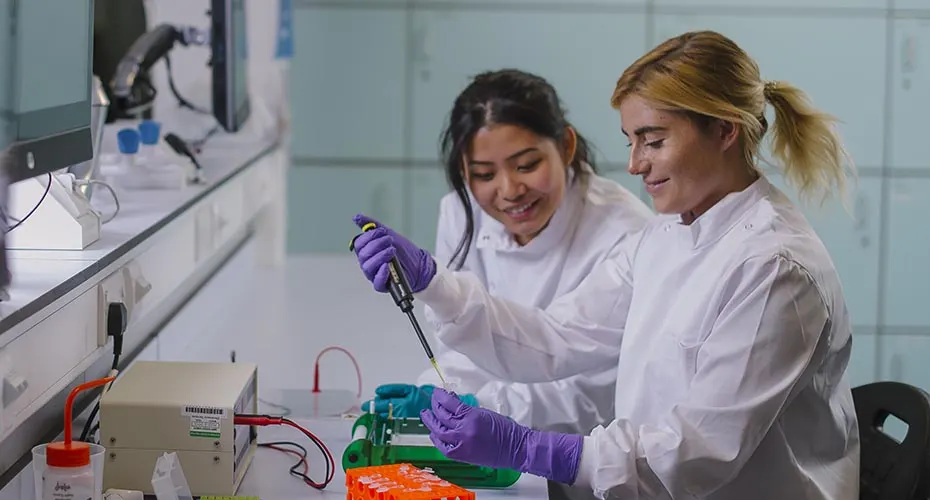 Two Biosciences students performing an experiment in the lab.