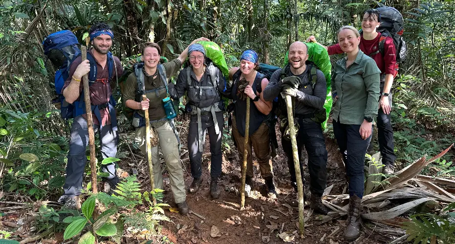 MSc Extreme Medicine students standing together in a jungle environment, wearing expedition gear and looking at the camera and smiling