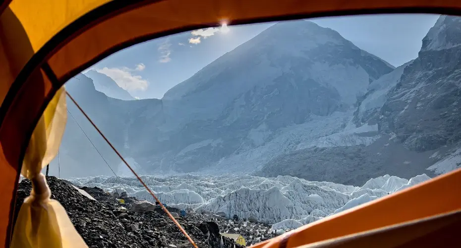 View of snowy mountain tops, taken from inside a tent looking out.