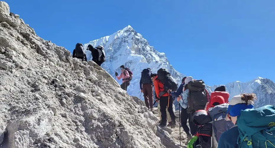 Group of Extreme Medicine students climbing up a steep rocky incline on a snowy mountain