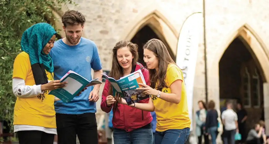 Two prospective students browsing our prospectus alongside a pair of student open day marshals
