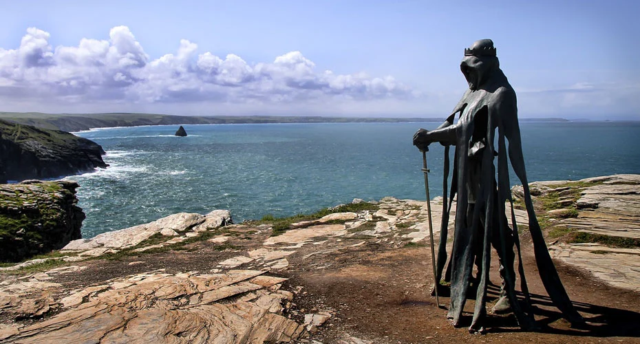 Sculpture of a monarch at Tintagel, with the sea in the background